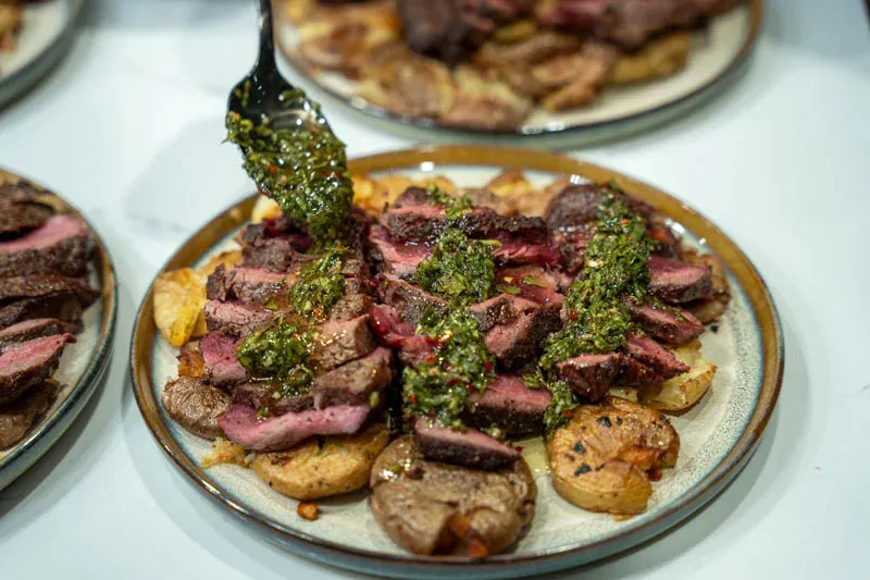 Private chef finishing steak with chimichurri and potatoes for a Las Vegas bachelor party
