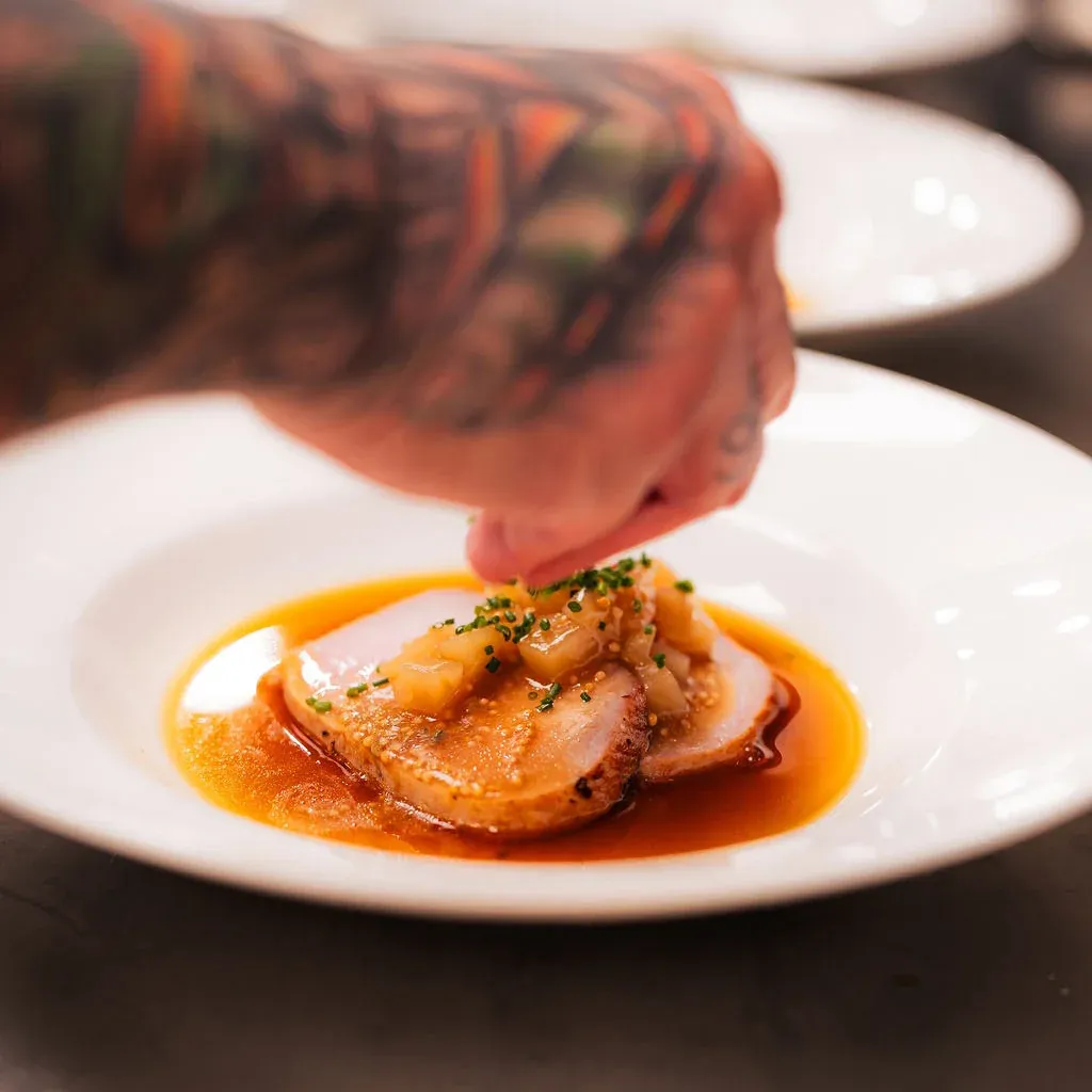 Private chef finishing pork medallions at a Las Vegas bachelor party dinner